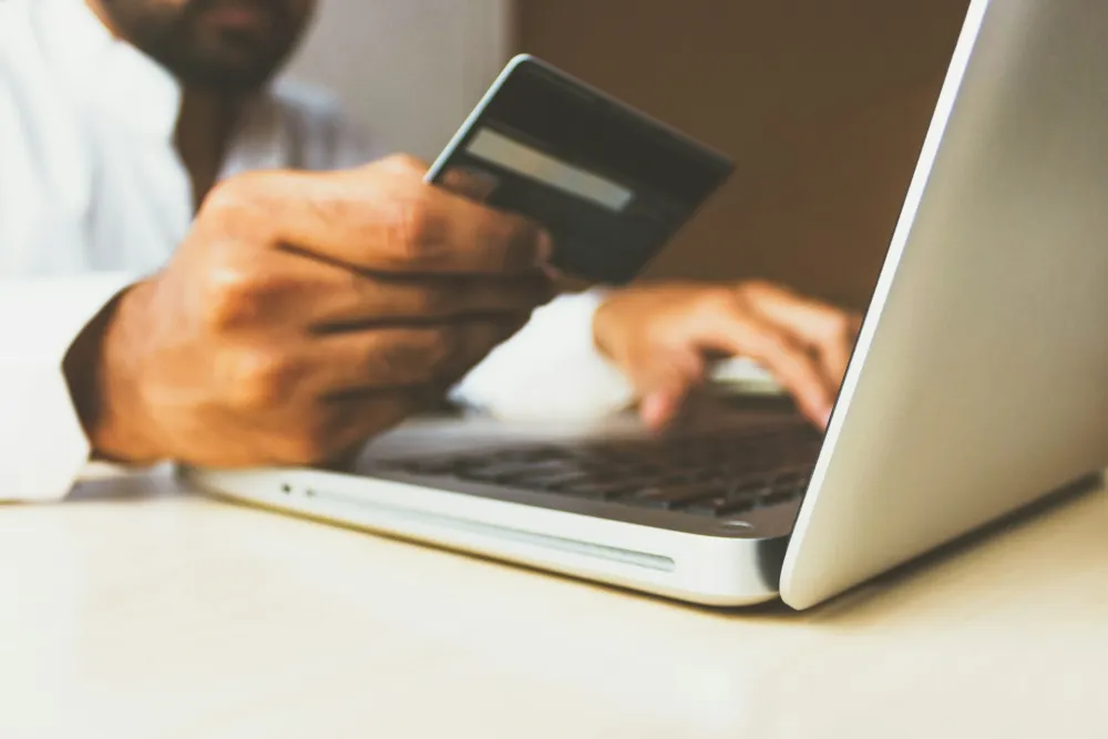 Paying an invoice online with a card and laptop